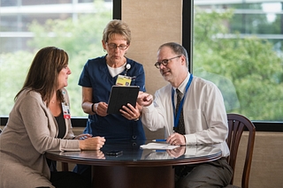 RNs and Health Administrator discussing a medical report.